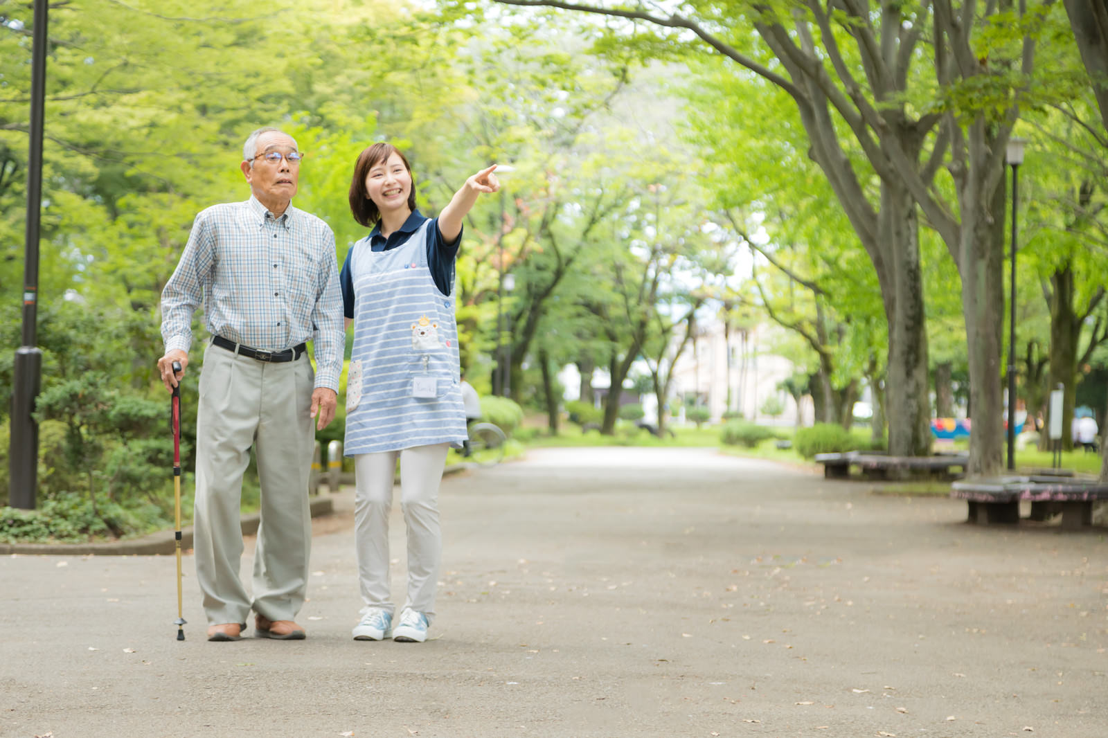 高齢者と介護スタッフが公園を歩く様子。相続や家族をテーマにしたFP3級学習記事のイメージ。