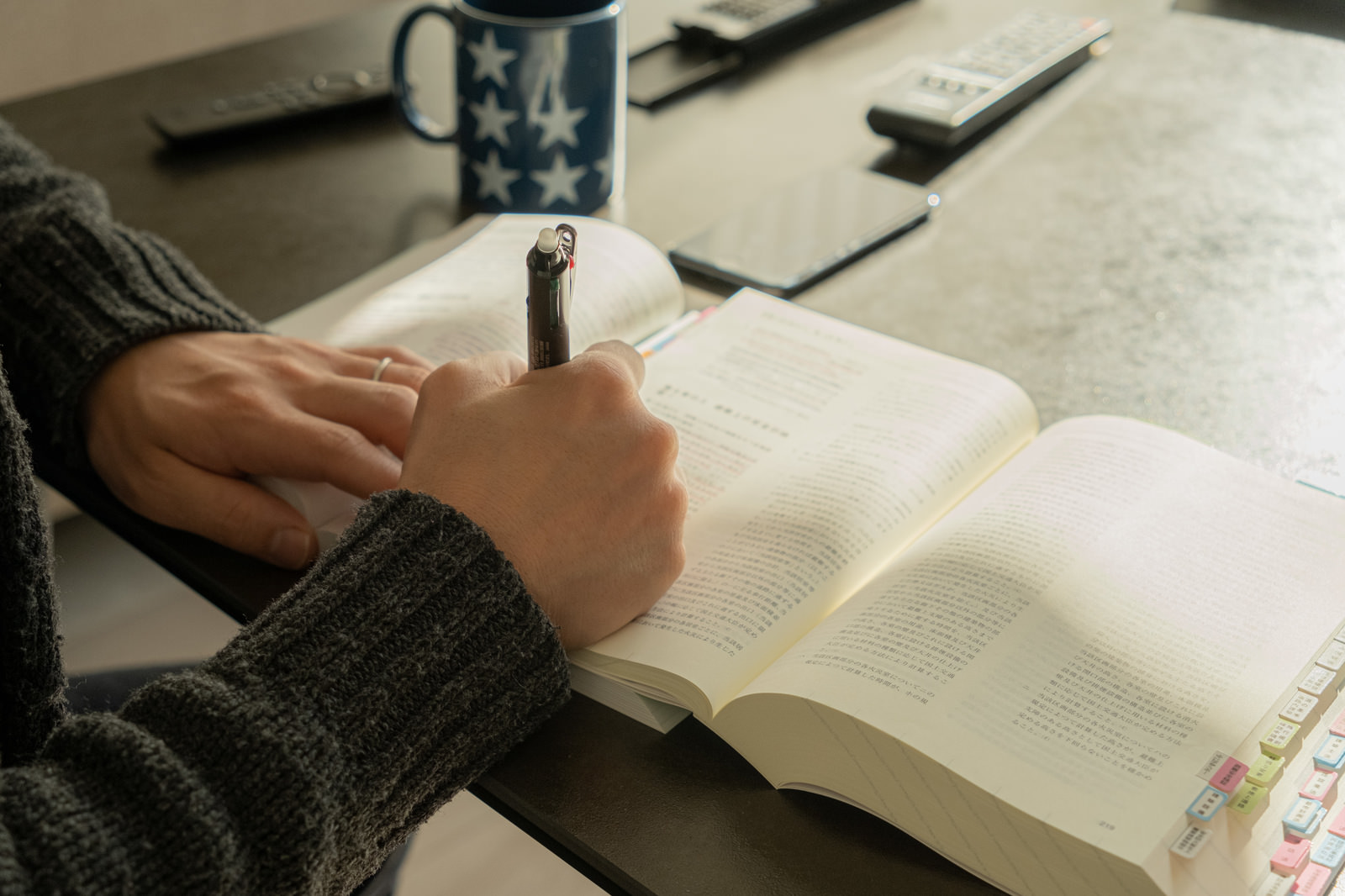 資格取得を目指して参考書に向かう社会人の勉強風景